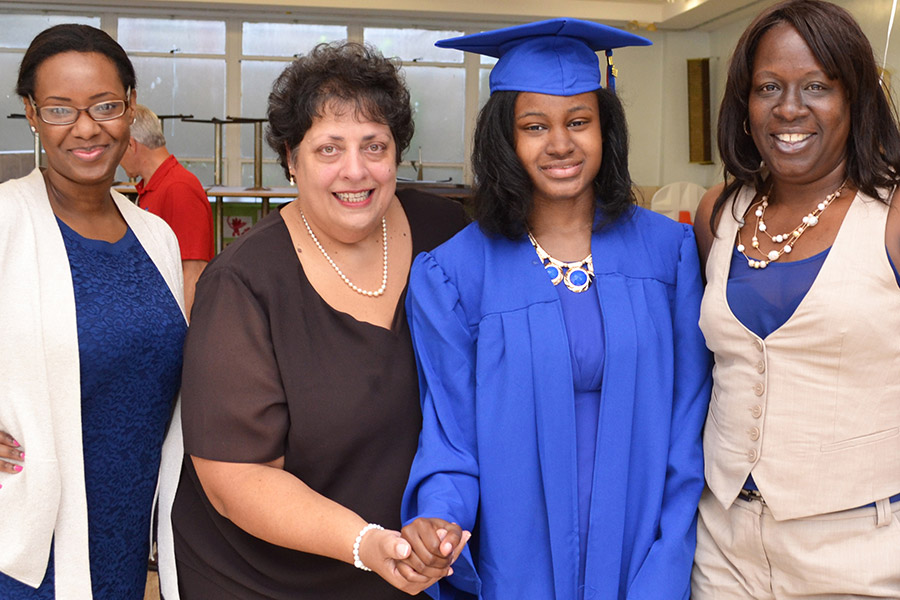 three women with student in graduation gown