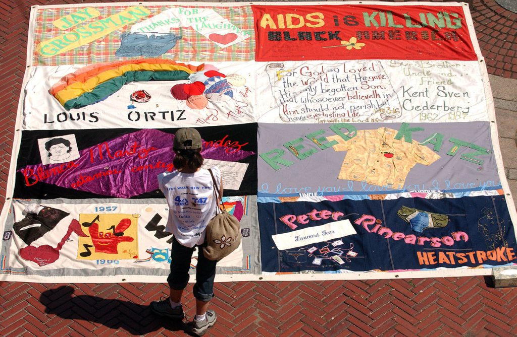person looking at large aids quilt