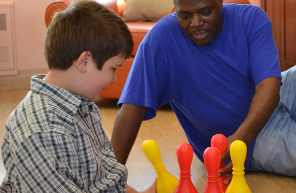 boy and man playing with toys on floor