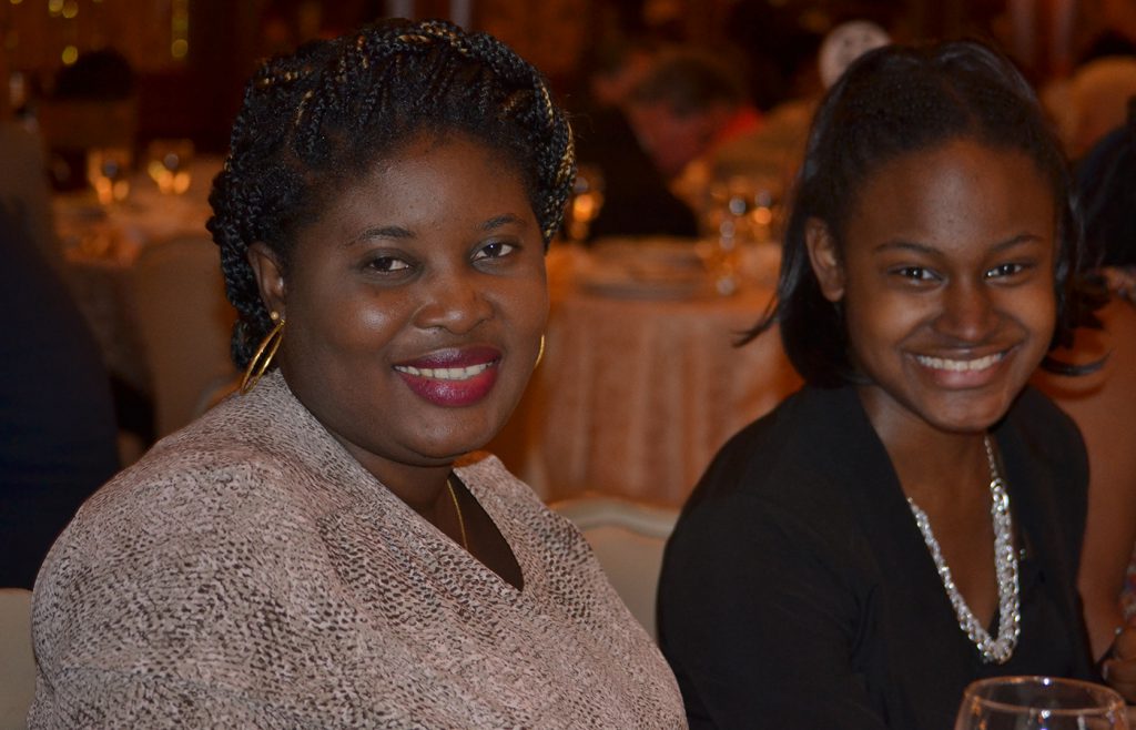 Two womens seated at a gala table.